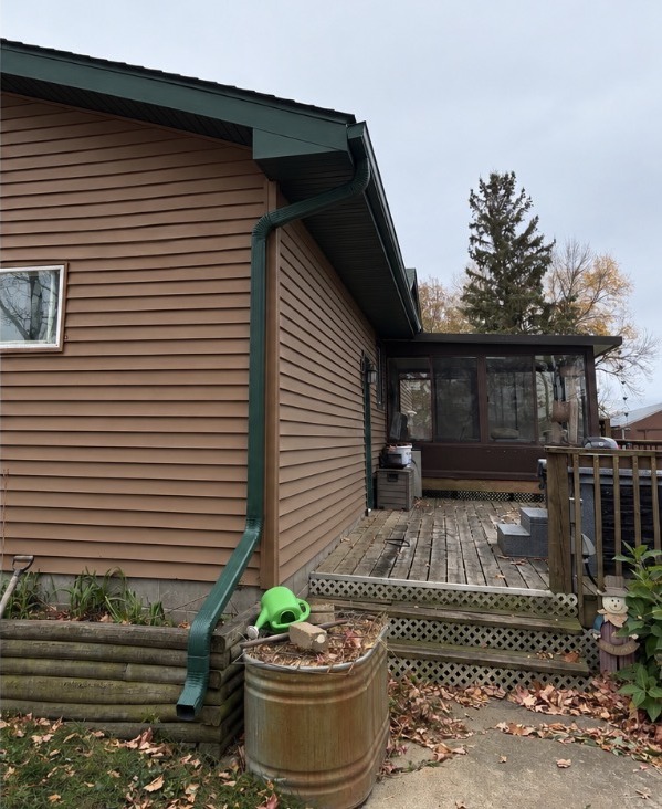 After: a new color-matched green gutter and downspout with a proper elbow extension